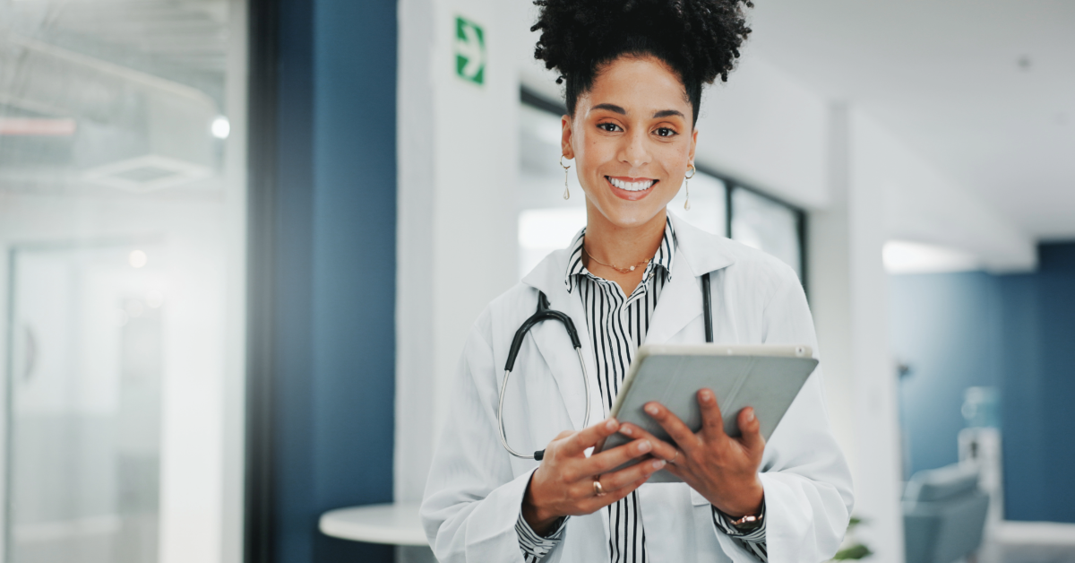 smiling woman with tablet in hospital setting
